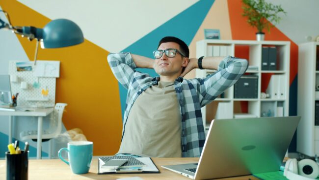 Homem que relaxa na mesa no escritório