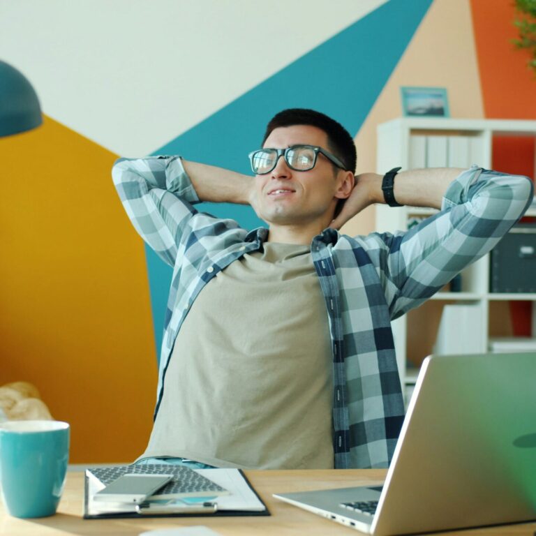 Homem que relaxa na mesa no escritório