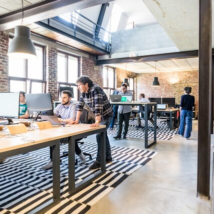 Colaboradores a trabalhar num escritório moderno, promovendo o bem-estar no ambiente de trabalho.